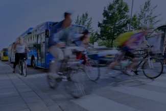 People cycling past city bus