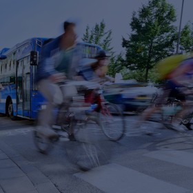 People cycling past city bus