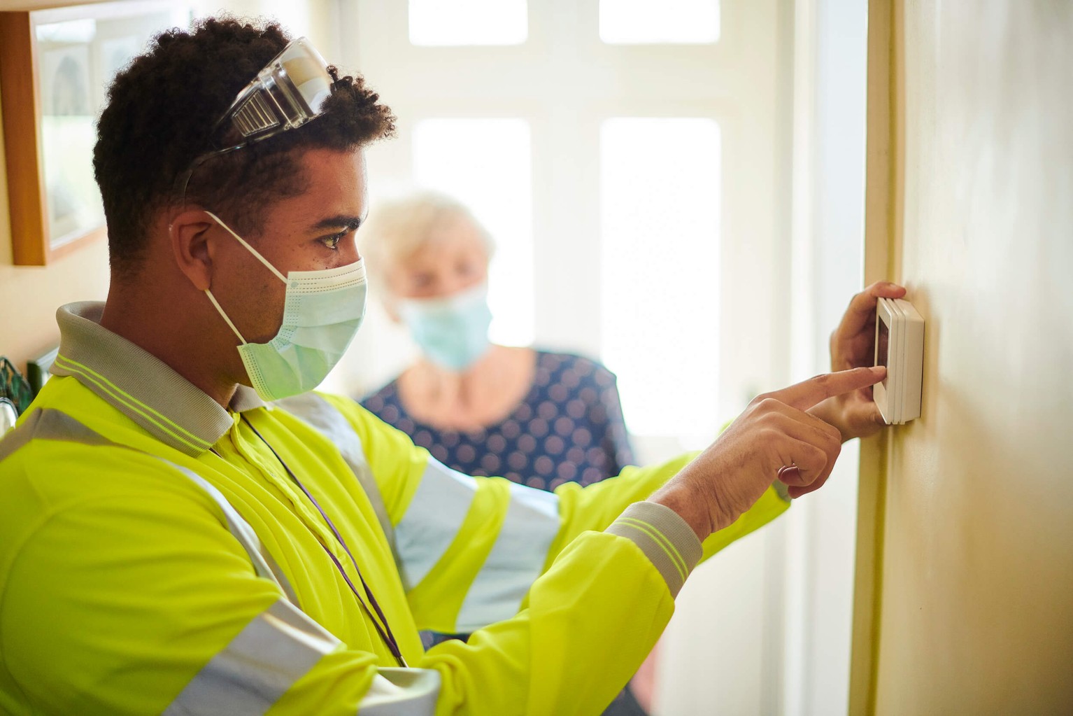 Man helping program thermostat