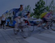 People cycling past city bus