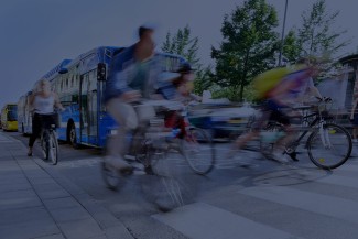 People cycling past city bus