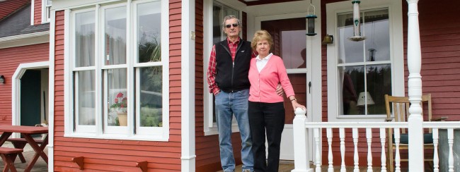Two people standing next to each other in front of a house