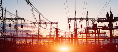 Power line transmission pylons at sunset
