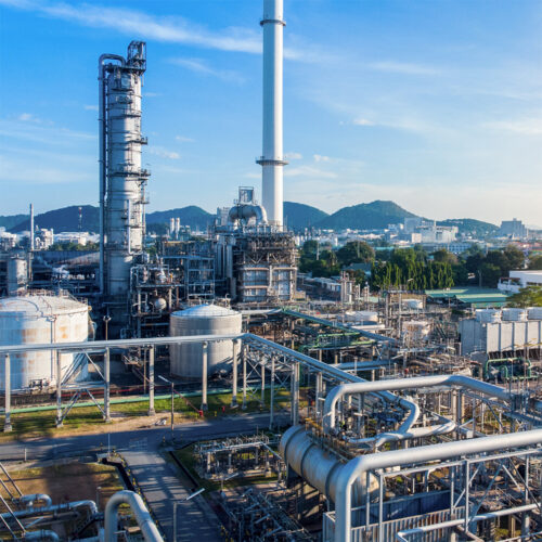 An aerial view of an industrial plant on a nice day with a blue sky in the background