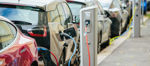 Electric cars parked on the street at chargers, where they are charging
