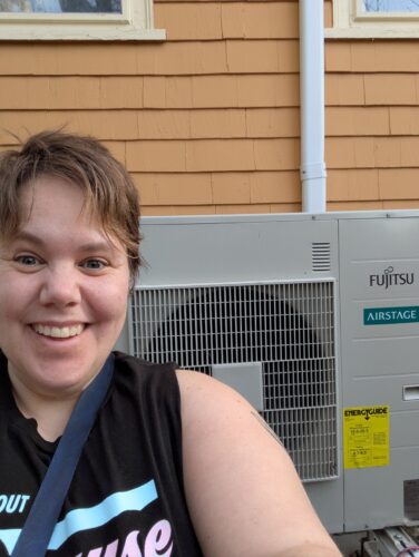 Woman standing in front of a heat pump