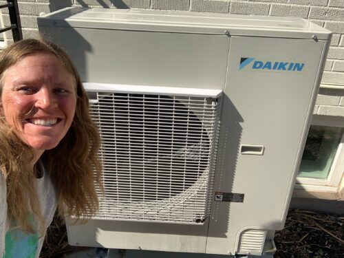 Woman standing in front of a heat pump