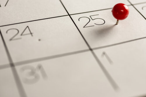 Close up shot of a red pin on the 25th day on calendar