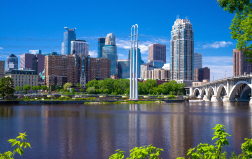 the mississippi river flows southward over st. anthony falls, and by the minneapolis skyline, on its way to the gulf of mexico.