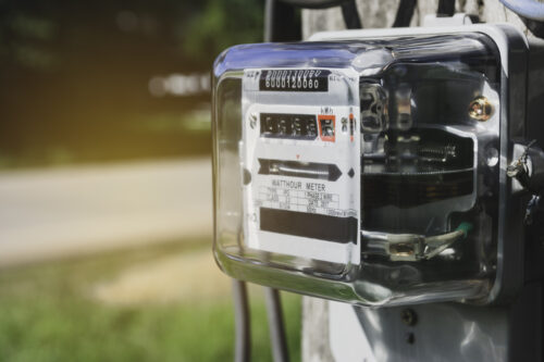 Electricity meter for house with sky background.