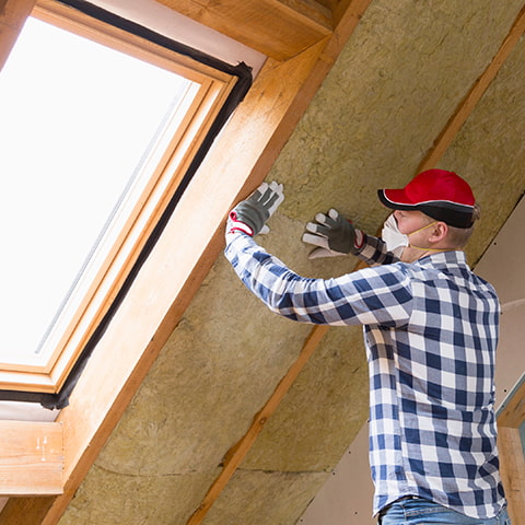 A worker installs insulation in a new home.