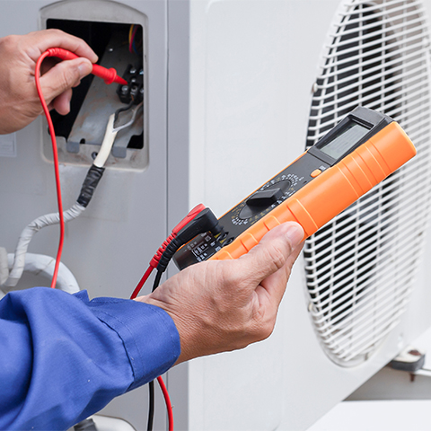 Technician working on a building AC unit