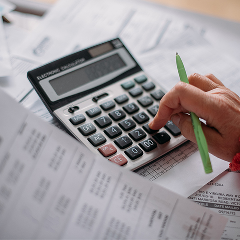 A person with a calculator and energy bills