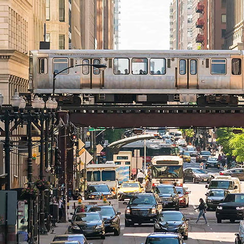 A busy street in downtown chicago, where people are getting around using multiple methods of transportation