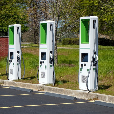 Electric vehicle chargers standing next to parking spots, ready to charge an electric car.